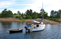 Sun Cat and dinghy at anchor near the rocky shore of Key Hole Cove in Lake Huron